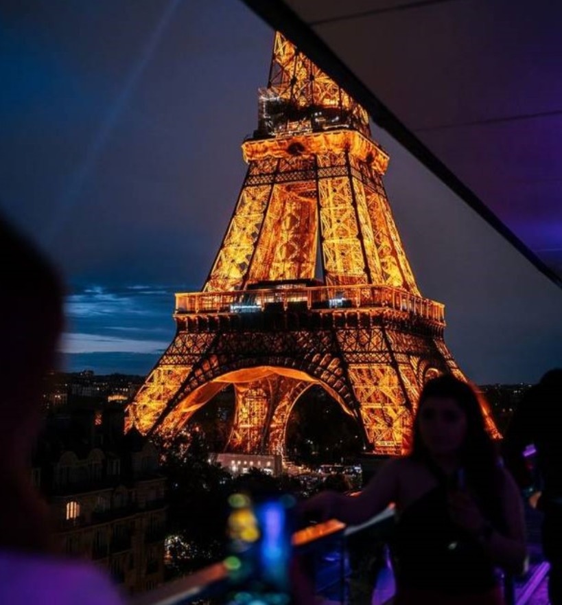 Tour Eiffel illuminée vue depuis une terrasse parisienne en soirée