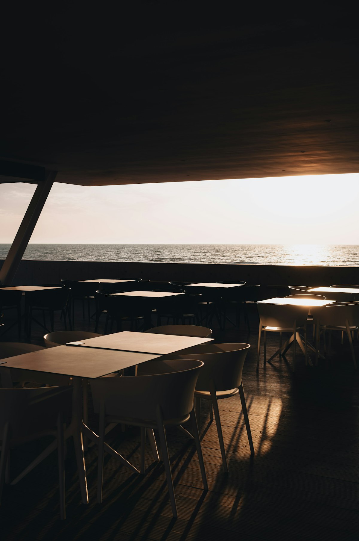 Tables au bord de la mer au soleil couchant